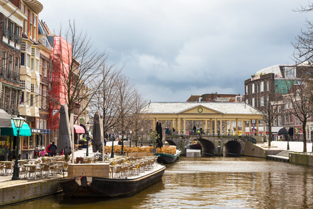 Leiden, Netherlands - April 7, 2016: Traditional houses, bridge and boat cafe in downtown of Leiden, Holland, Netherlandsのeditorial素材