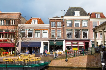 Leiden, Netherlands - April 7, 2016: Traditional houses, boat cafe and people in downtown of Leiden, Holland, Netherlandsのeditorial素材