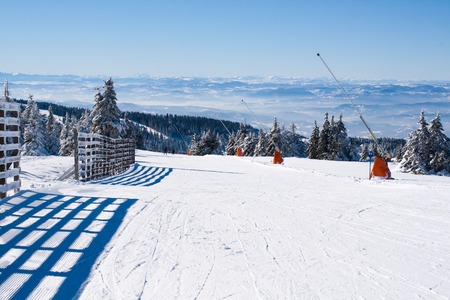 Ski resort, ski slope, people skiing down the hill, mountains viewの写真素材
