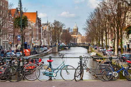 Amsterdam, Netherlands - March 31, 2016: Traditional old buildings, canal and bridge view with bicycles in Amsterdam, the Netherlandsのeditorial素材