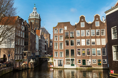 Amsterdam, Netherlands - April 2, 2016: Traditional old buildings, church, canal and bridge view with bicycles in Amsterdam, the Netherlandsのeditorial素材