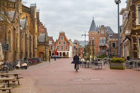 Haarlem, Netherlands - April 2, 2016: Picturesque landscape with people, beautiful traditional houses and man riding bike, Haarlem, Hollandのeditorial素材