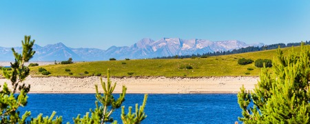 Beautiful summer landscape panorama of the lake, pine trees and mountains on the backgroundの写真素材