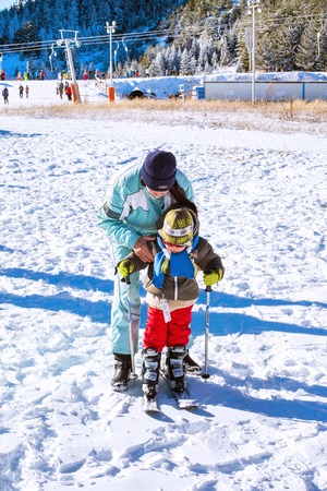 Bansko, Bulgaria - December, 12, 2015: The small child learning to ski with mother  on the slope in Bansko, Bulgariaのeditorial素材
