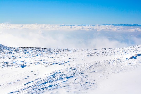 Panorama of white snow mountain landscape with fog and cloudsの写真素材