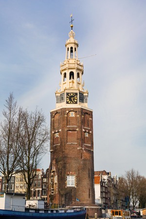 Grand old clock tower in Amsterdam, Netherlands against blue cloudy skyの写真素材