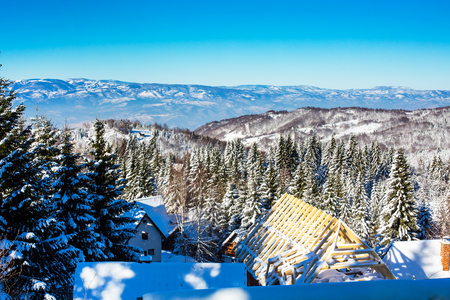 Vibrant aerial winter mountain panorama landscape with snowy pine trees, blue skyの写真素材