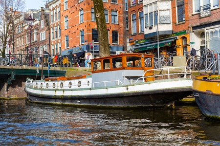 Amsterdam, Netherlands - April 1, 2016: Traditional boat house, canal, bridge in Amsterdam, Hollandのeditorial素材