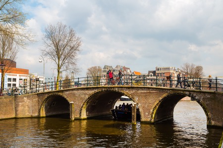 Amsterdam, Netherlands - April 2, 2016: Traditional old buildings, canal and bridge view with bicycles in Amsterdam, the Netherlandsのeditorial素材