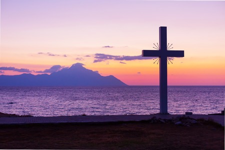 Silhouette of cross and mount Athos at sunrise or sunset and sea panorama in Greeceの写真素材