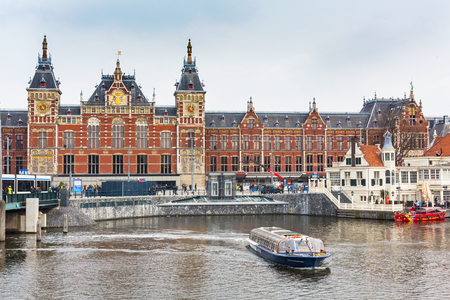 Amsterdam, Netherlands - April 2, 2016: Railway station, cruise boat with tourists and canal view in Amsterdam, Netherlandsのeditorial素材