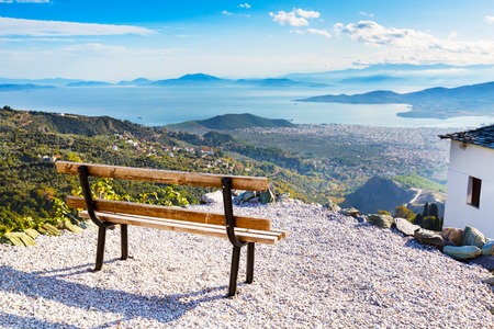 Bench overlooking Volos city and sea gulf aerial view from Pelion mount, Greeceの写真素材