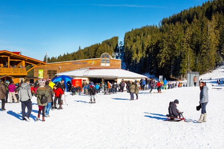 Bansko, Bulgaria - December 12, 2015: Bunderishka polyana, ski station, cable car lift, Bansko, Bulgaria,  blue cabins and mountain with pine trees, peopleのeditorial素材