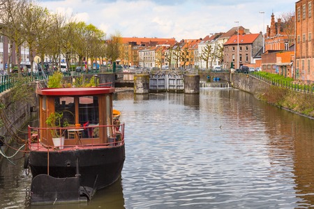 Panorama with old colorful traditional houses, canal and boat in popular touristic destination Ghent, Belgiumの写真素材