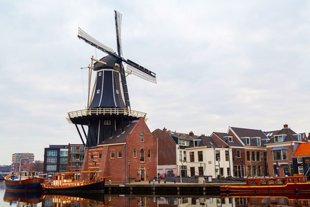Haarlem, Netherlands - April 2, 2016: Picturesque morning landscape with the windmill and traditional houses, Haarlem, Hollandのeditorial素材