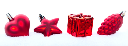 Christmas holiday decorations, red heart, pine cone and gift in the snow on white panoramic banner backgroundの写真素材