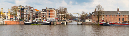 Amsterdam, Netherlands - April 2, 2016: Traditional old buildings, canal and bridge panoramic view in Amsterdam, the Netherlandsのeditorial素材