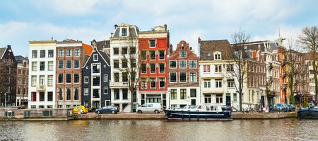 Traditional old buildings, canal and boat in Amsterdam, the Netherlandsの写真素材