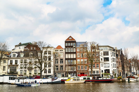Amsterdam, Netherlands - April 2, 2016: Traditional old buildings, canal and boat in Amsterdam, the Netherlandsのeditorial素材