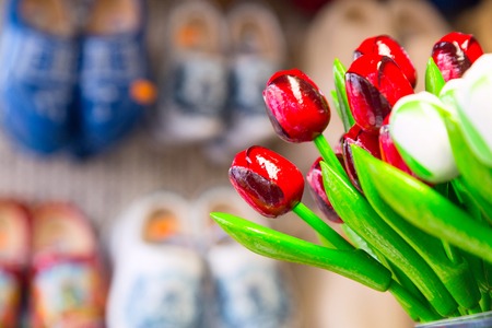 Holland symbol red souvenir tulips and dutch traditional wooden shoes or clogs for sale in shop in Netherlandsの写真素材