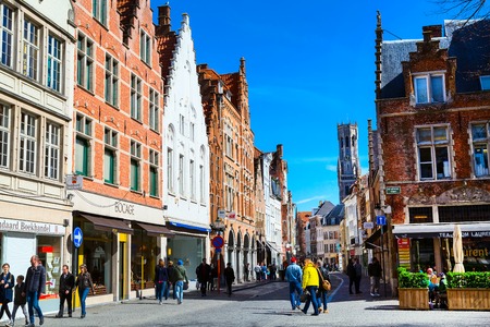 Bruges, Belgium - April 10, 2016: Street view with medieval traditional houses and tower Belfort in popular belgian destinationのeditorial素材