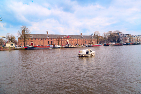 Amsterdam, Netherlands - April 2, 2016: Traditional old buildings, canal and boat view in Amsterdam, the Netherlandsのeditorial素材