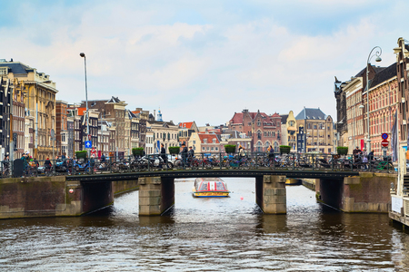 Amsterdam, Netherlands - April 1, 2016: Traditional dutch houses, canal and bridge with bycicles in Amsterdam, Hollandのeditorial素材