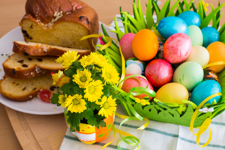 Easter background with spring yellow flowers, colorful Easter eggs and traditional Easter cakeの写真素材