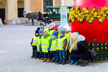 Vienna, Austria - April 3, 2015: The group of children taking photo in front of the large red Easter egg near the Schonbrunn palace in Viennaのeditorial素材