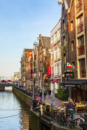 Amsterdam, Netherlands - April 1, 2016: Traditional old buildings, people, canal and bridge view with bicycles in Amsterdam, Hollandのeditorial素材