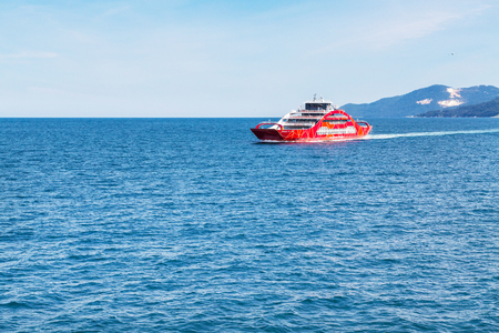 Keramoti, Greece - May 1, 2016: Red ferry boat going to Thassos from Keramoti port, blue sea and skyのeditorial素材
