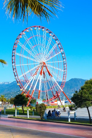 Batumi, Georgia - April 30, 2017: Ferris wheel, city panoramic landscape with mountain peaks, summer Black sea resortのeditorial素材