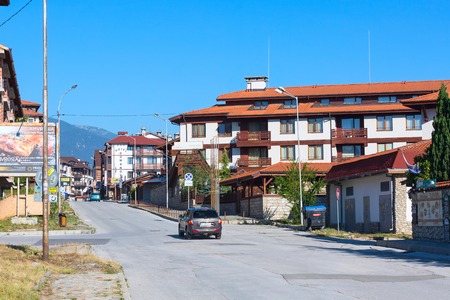 Bansko, Bulgaria - July 19, 2017: Summer street view with wooden chalet hotel houses and summer Pirin mountains panorama in bulgarian all season resortのeditorial素材