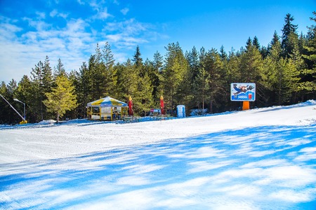Bansko, Bulgaria - February 19, 2015: Ski slope in Bansko, Bulgaria, pine trees, small cafe and mountains viewのeditorial素材