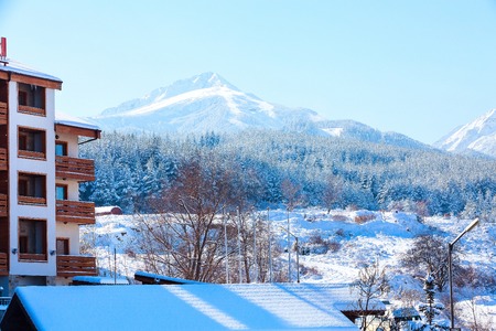 House hotel and ski slopes, snow mountains panorama in bulgarian ski resort Banskoの写真素材