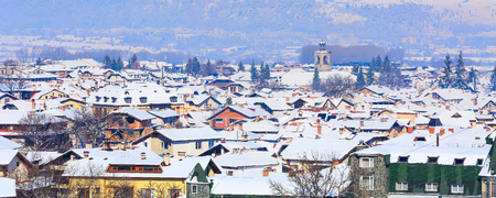 Houses with snow roofs and church tower panorama banner of bulgarian ski resort Bansko, Bulgariaの写真素材