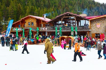 Bansko, Bulgaria - December 16, 2017: Restaurant at Bunderishka polyana, skiers and mountain with pine trees panoramaのeditorial素材