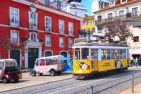 Lisbon, Portugal - March 27, 2018: Yellow tram 28, symbol of Lisbon at colorful downtown streetのeditorial素材