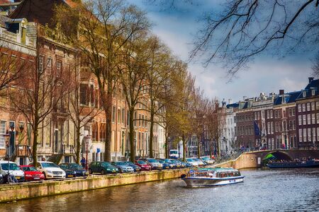 Amsterdam, Netherlands - April 2, 2016: Traditional old buildings, canal and boats in Amsterdam, Hollandのeditorial素材