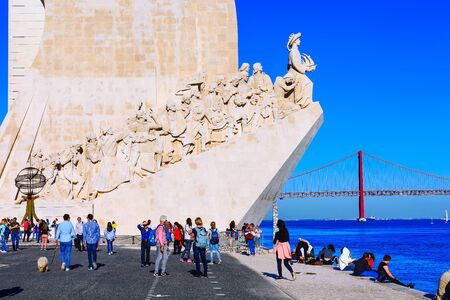 Lisbon, Portugal - March 27, 2018: People near River Tagus, Ponte de 25th Abril bridge and Monument to the Discoveries dedicated to the Portuguese Explorersのeditorial素材