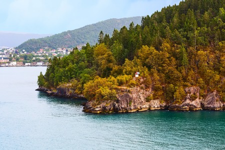 Norwegian landscape with turquoise fjord water, mountains and lighthouseの写真素材