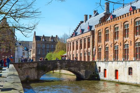 Bruges, Belgium - April 10, 2016: Scenic cityscape with houses, people on bridge and canal in Bruges, Belgiumのeditorial素材