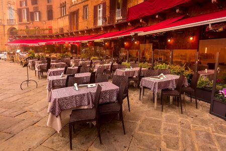 Siena, Italy - October 25, 2018: Cafe and restaurants tables at Campo Square or Piazza del Campo with Tower Torre del Mangia in Tuscany townのeditorial素材