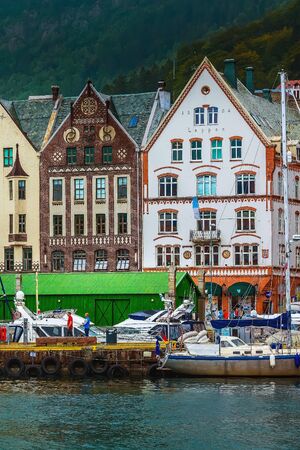 Bergen, Norway - July 30, 2018: City street view with Bryggen hanseatic wharf, boats and colorful traditional nordic housesのeditorial素材