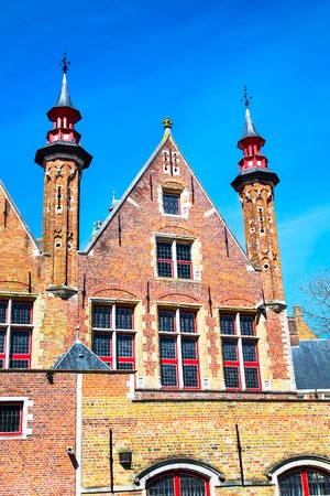 Traditional medieval brick house exterior against blue sky in belgian destination Bruges, Belguimの写真素材