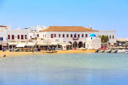 Mykonos, Greece - April 23, 2019: Famous island white houses, promenade, beach, view from the sea in Cycladesのeditorial素材