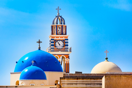 Greek orthodox church bell tower and domes against blue sky, Santorini, Greece, Firaの写真素材