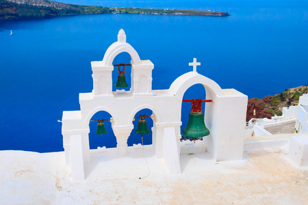 Sea and iconic view of blue and white church bell tower, Santorini, Greeceの写真素材