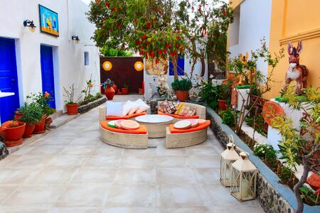 Oia, Santorini - April 25, 2019: Oia, cafe in Santorini island, Greece with traditional decorations, donkeys and sofa chairsのeditorial素材