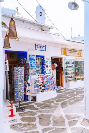 Mykonos, Greece - April 23, 2019: Famous island street view with white houses and souvenir gift shop in Cycladesのeditorial素材